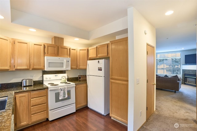 kitchen with dark hardwood / wood-style flooring, dark stone countertops, light brown cabinetry, and white appliances