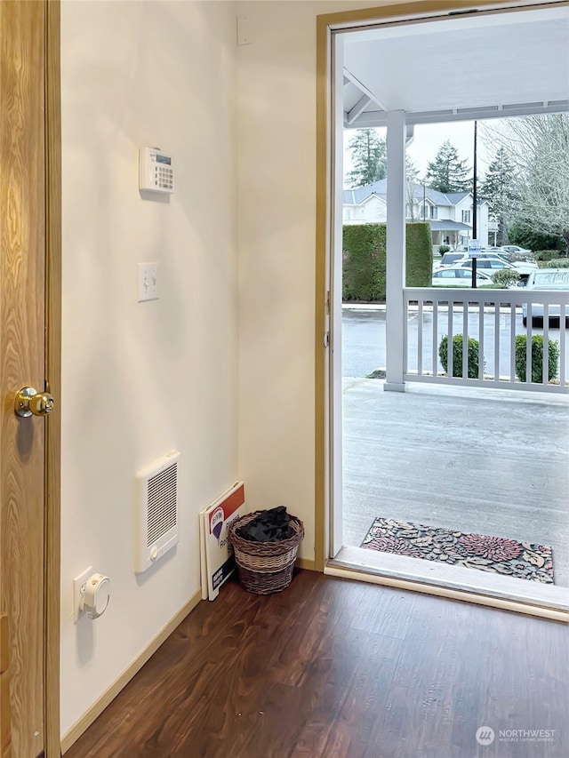 doorway with dark hardwood / wood-style flooring and heating unit