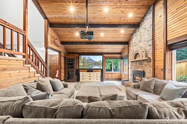 living room with a brick fireplace, beamed ceiling, high vaulted ceiling, wood walls, and wood ceiling