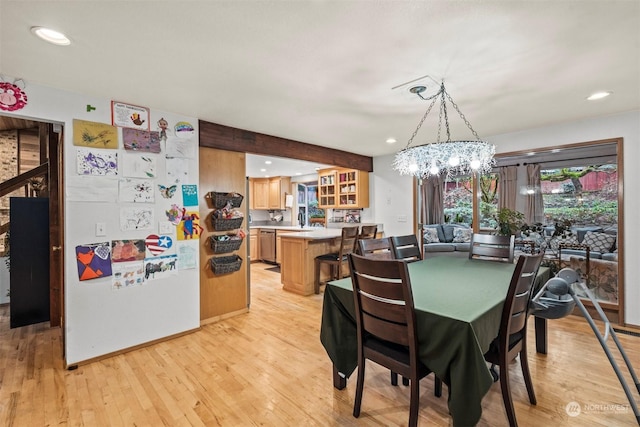 dining space with beamed ceiling, light hardwood / wood-style floors, and an inviting chandelier