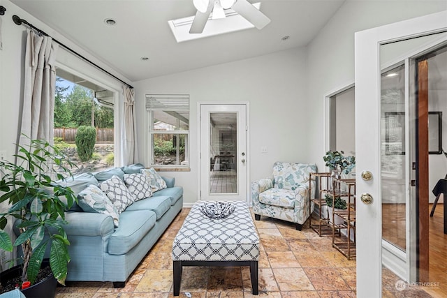 living room with lofted ceiling with skylight and ceiling fan