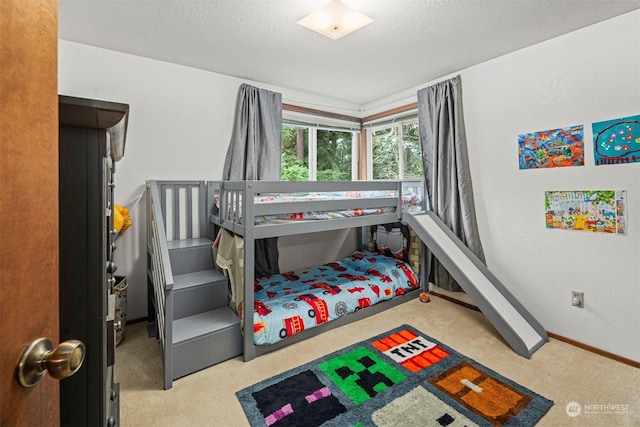 bedroom featuring light carpet and a textured ceiling