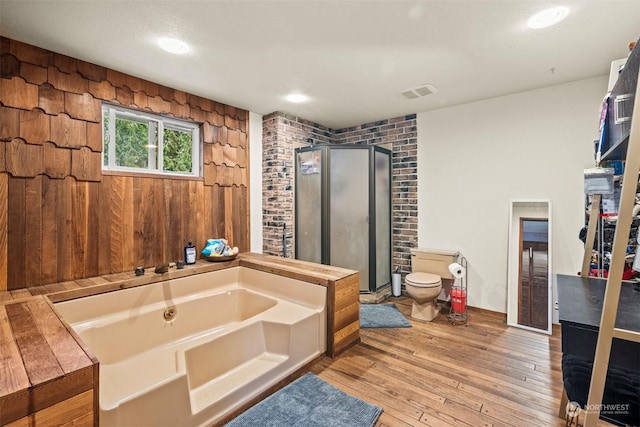 bathroom with plus walk in shower, hardwood / wood-style floors, and toilet