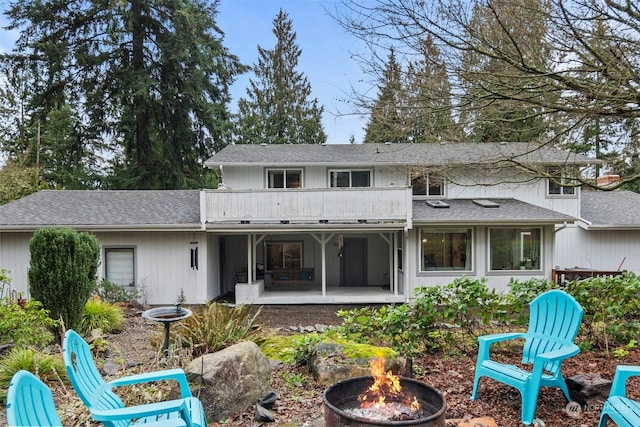 back of house featuring a patio, a balcony, and a fire pit