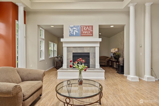 living room with a tile fireplace and light hardwood / wood-style flooring