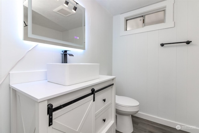 bathroom featuring vanity, toilet, and wood-type flooring