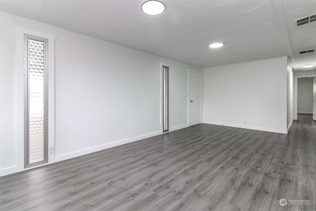 empty room with dark hardwood / wood-style flooring