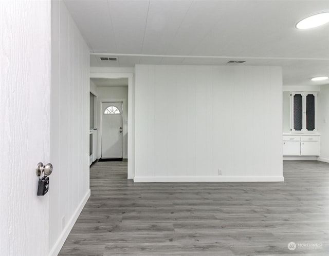 unfurnished room featuring wood-type flooring and wood walls