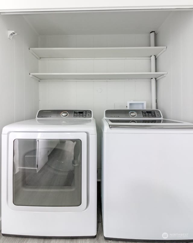 laundry room featuring light wood-type flooring and separate washer and dryer