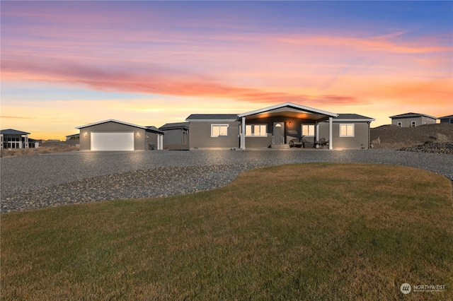 view of front of home with a garage and a lawn