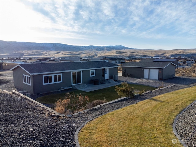 exterior space featuring a mountain view, a patio area, and a yard