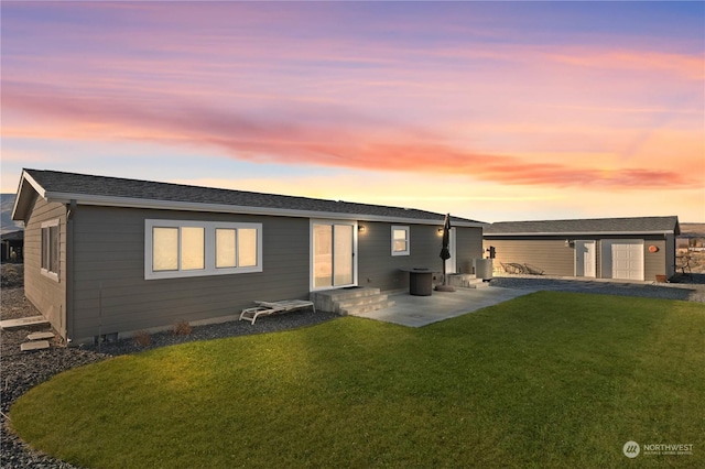 back house at dusk featuring central AC unit, a patio area, a yard, and a garage