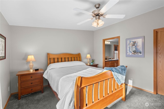 bedroom with ceiling fan, dark carpet, and connected bathroom