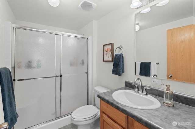 bathroom with a shower with shower door, vanity, and toilet