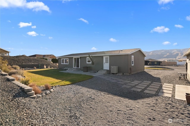 rear view of house with a mountain view and a lawn