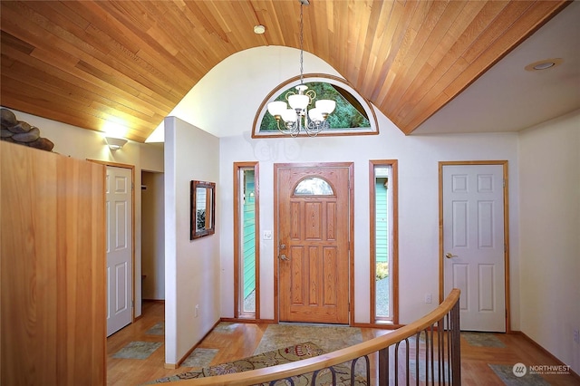 foyer featuring a chandelier, light wood-type flooring, lofted ceiling, and wood ceiling