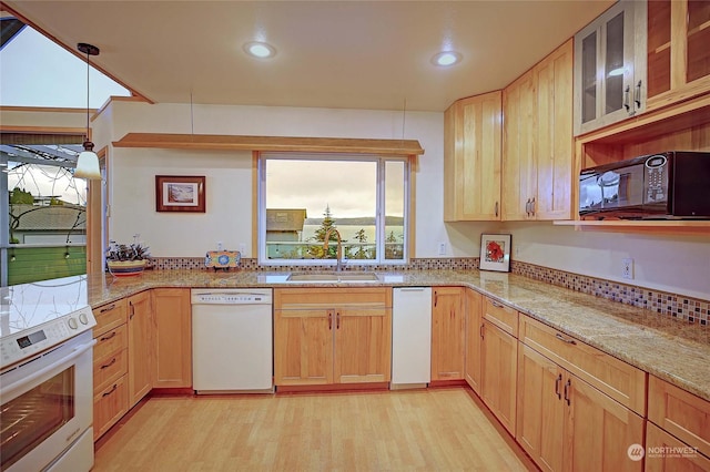 kitchen featuring sink, light stone counters, pendant lighting, light hardwood / wood-style floors, and white appliances