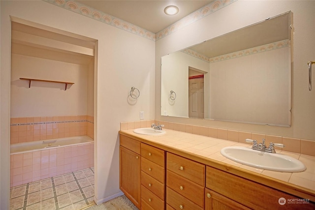 bathroom featuring vanity, a relaxing tiled tub, and tile patterned floors