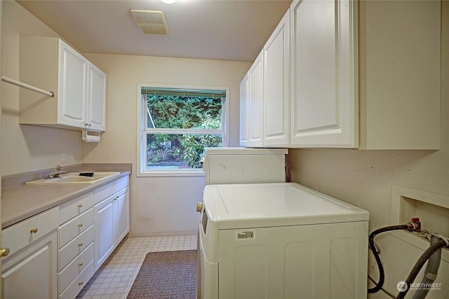 laundry area featuring cabinets, sink, and washer / clothes dryer