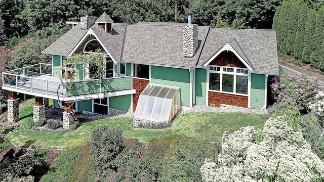 337 Moana Dr, Camano Island, WA 98282 - rear view of property featuring a chimney, an exterior structure, a shingled roof, a lawn, and a wooden deck