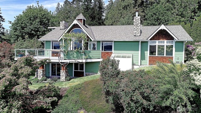 337 Moana Dr, Camano Island, WA 98282 - back of house featuring a chimney, roof with shingles, and a lawn