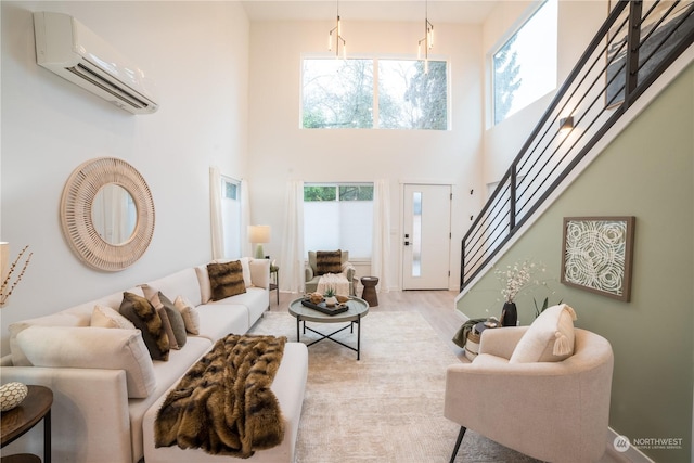 living room featuring an AC wall unit, light hardwood / wood-style floors, and a high ceiling