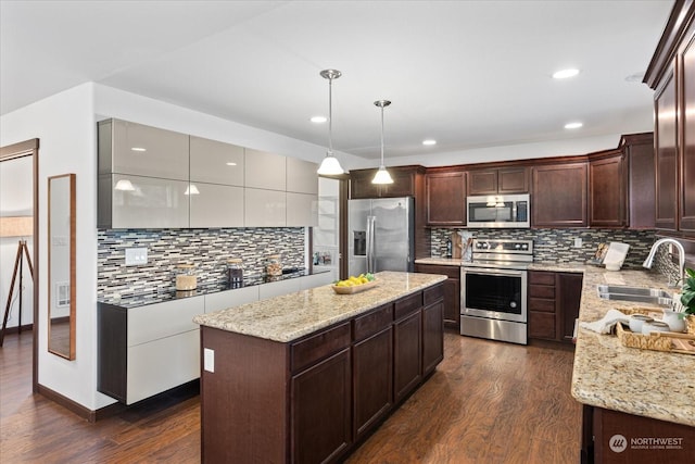 kitchen featuring sink, a center island, hanging light fixtures, dark hardwood / wood-style flooring, and appliances with stainless steel finishes