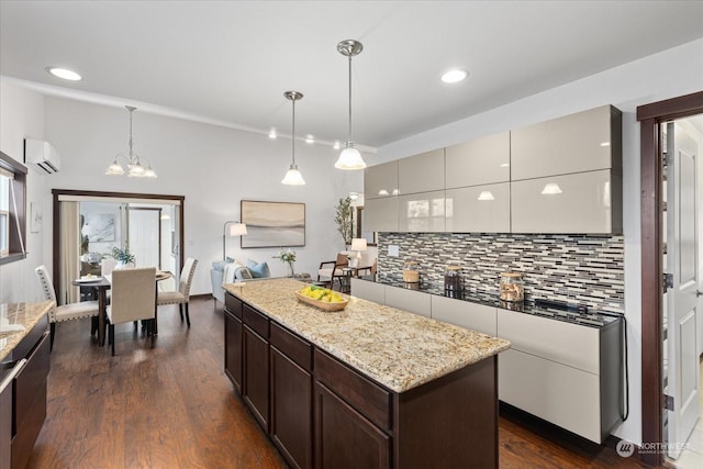 kitchen featuring an AC wall unit, tasteful backsplash, dark wood-type flooring, and decorative light fixtures