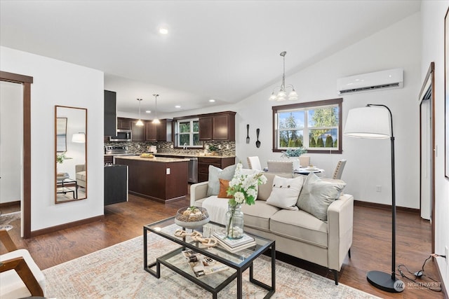 living room with sink, dark wood-type flooring, an inviting chandelier, an AC wall unit, and lofted ceiling