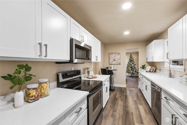 kitchen featuring white cabinets, stainless steel appliances, dark wood-type flooring, and sink