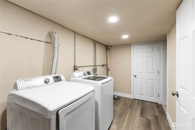 laundry room featuring separate washer and dryer and hardwood / wood-style flooring