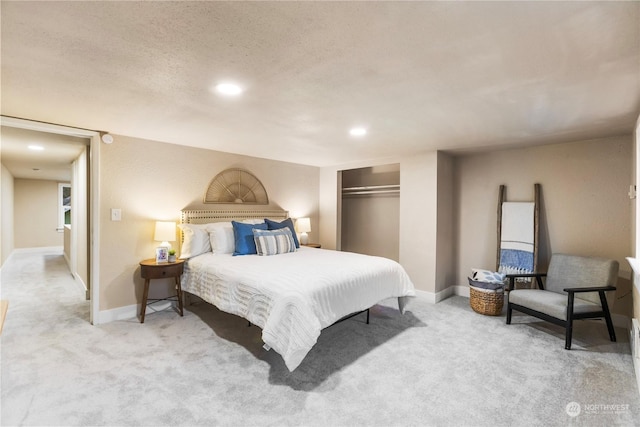 carpeted bedroom featuring a textured ceiling and a closet