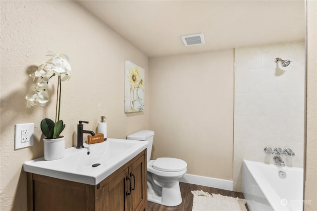 bathroom with a tub, vanity, wood-type flooring, and toilet