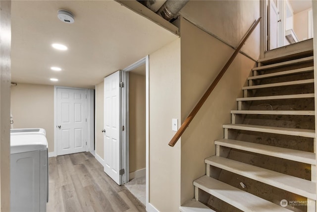 stairway with hardwood / wood-style floors and washer / dryer