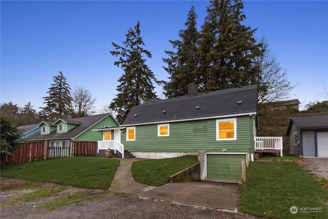 rear view of house with a yard and a garage