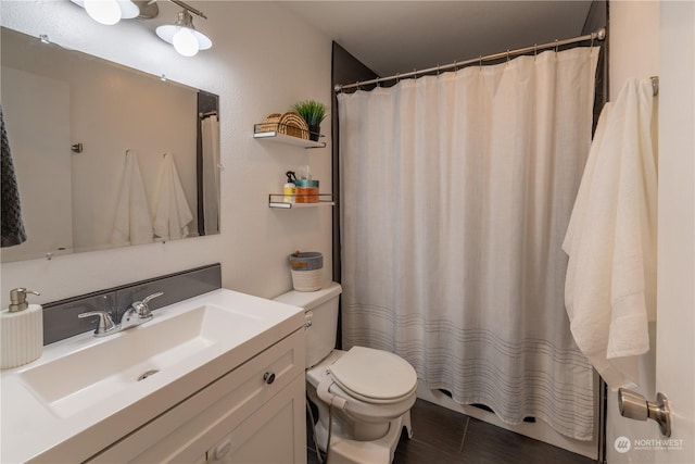 bathroom featuring toilet, curtained shower, tile patterned floors, and vanity