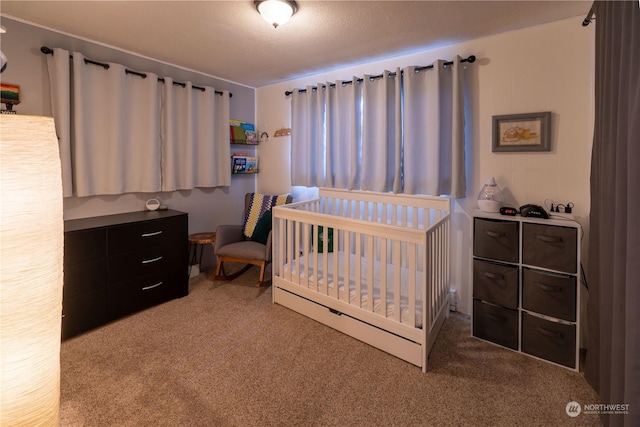 carpeted bedroom featuring a crib