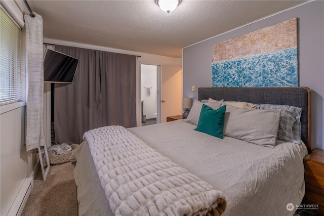 bedroom with a textured ceiling, carpet flooring, and a baseboard heating unit