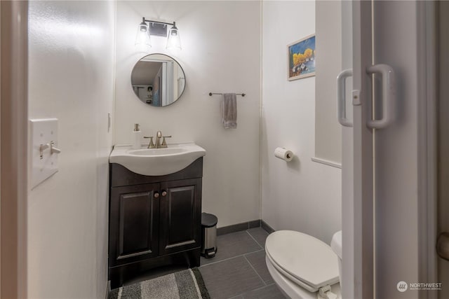 bathroom with toilet, vanity, and tile patterned floors