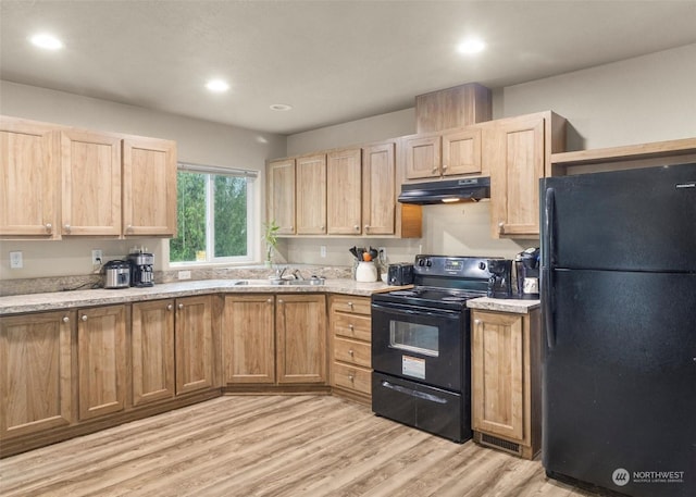 kitchen with light stone countertops, sink, black appliances, and light hardwood / wood-style floors