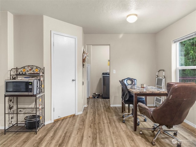 home office featuring washer / dryer, a textured ceiling, and light hardwood / wood-style floors