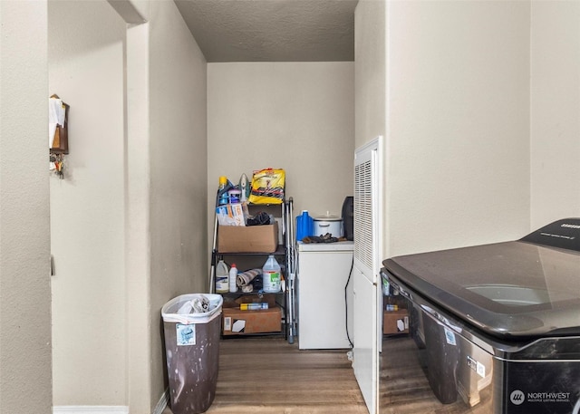 washroom featuring separate washer and dryer, hardwood / wood-style floors, and a textured ceiling