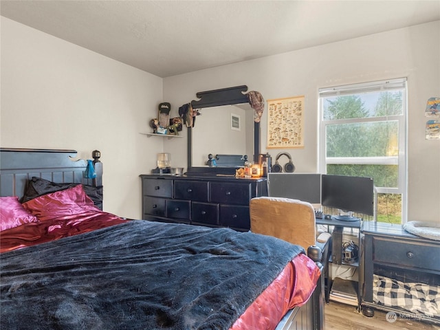 bedroom with hardwood / wood-style flooring and multiple windows