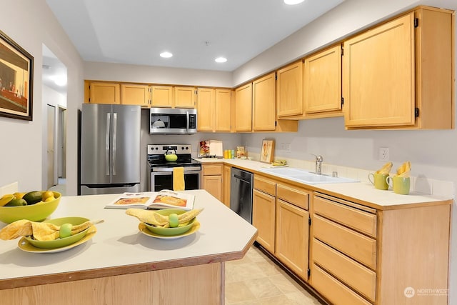 kitchen with appliances with stainless steel finishes, light brown cabinetry, and sink