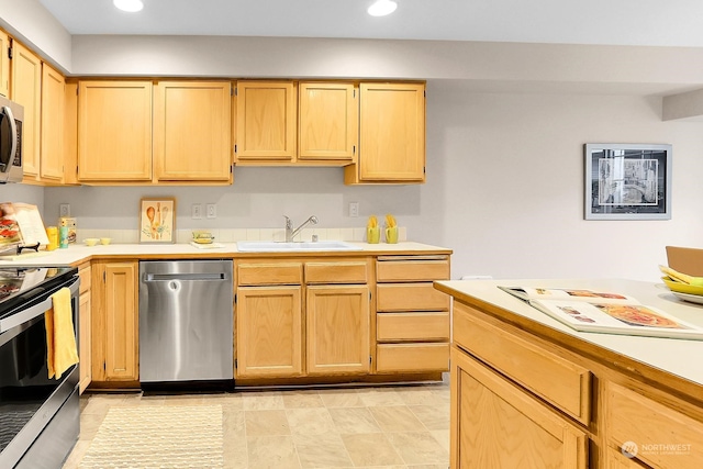 kitchen featuring appliances with stainless steel finishes, light brown cabinets, and sink