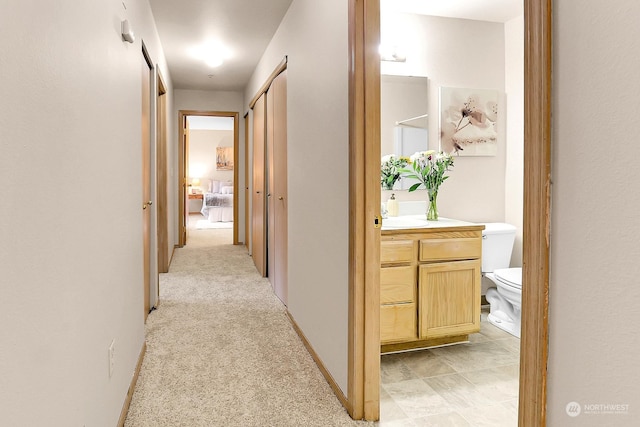 hallway featuring light colored carpet