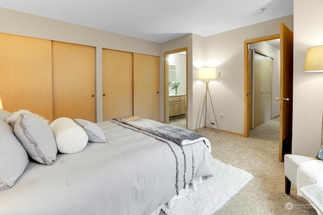 bedroom featuring light carpet and connected bathroom