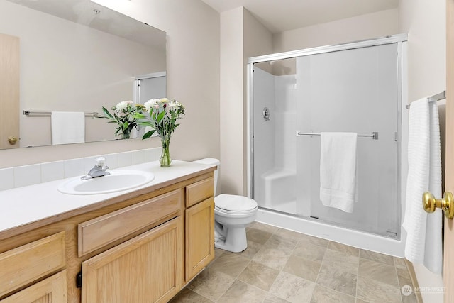 bathroom with vanity, toilet, and a shower with shower door