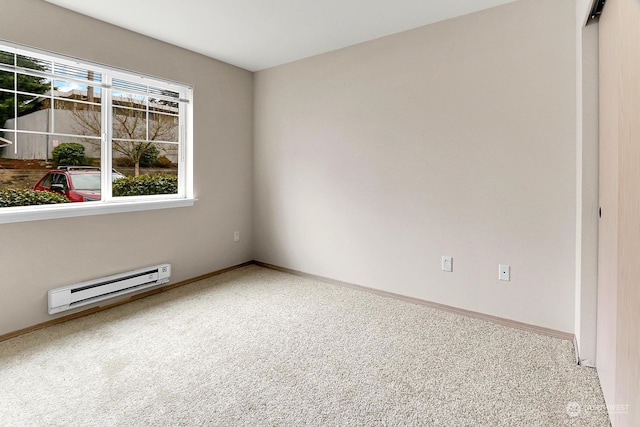 carpeted spare room featuring a baseboard heating unit