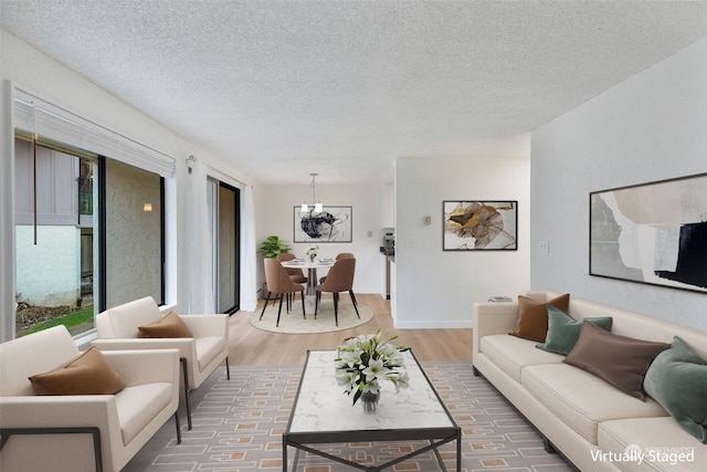 living room featuring a chandelier, hardwood / wood-style floors, and a textured ceiling